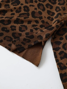 Detail of leopard print knit sweater featuring ribbed hem and side slit craftsmanship
