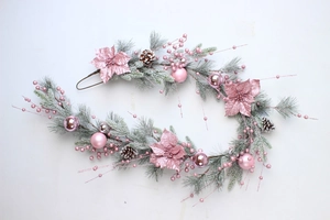 Detail of pink Christmas garland with frosted pine needles and decorative baubles