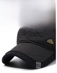 Detailed close-up of quilted black winter baseball cap fabric and metal China logo