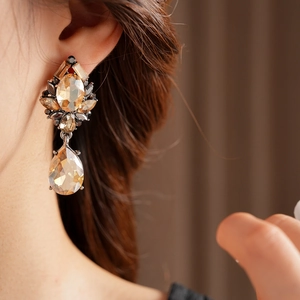 Close-up of vintage teardrop earrings with champagne crystals and dark metal base
