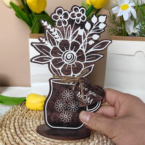 Detail of wooden flower ornament with Love you MOM tag on a woven mat for Mother's Day