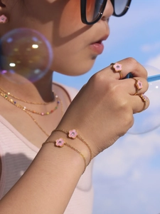 Detail van de gouden sieradenset voor kinderen met roze bloemen en fonkelende zirkoon