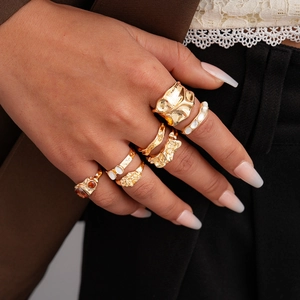 Detailed view of six gold-plated vintage rings with pearlescent and amber stones