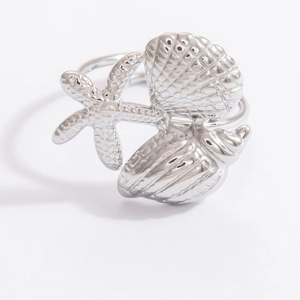 Macro shot of polished stainless steel ring with starfish, shell, and conch design elements