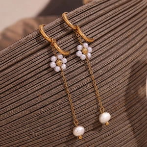 Detail of 18K gold-plated earring with handmade pearl flower and long tassel fringe