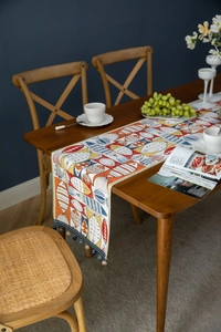 Detail of Chenille table runner featuring colorful Nordic fish patterns and blue tassels