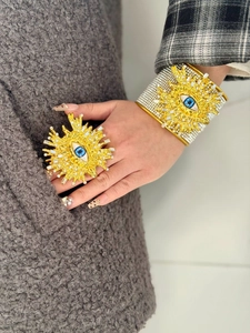 Detalle de conjunto de brazalete y anillo Evil Eye vintage dorado con incrustaciones.