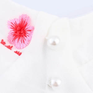 Robe blanche avec broderie florale rose et boutons de perles sur maille fine