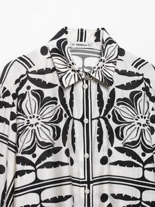 Détail du col de chemise et des boutons avec imprimé floral symétrique noir et blanc