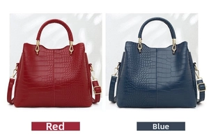 Detail of red and blue crocodile embossed tote bags with gold metallic hardware
