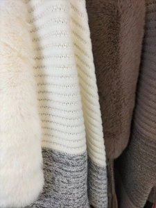 Detail of high-weight knit fabric and thick faux fur collar with fringe texture