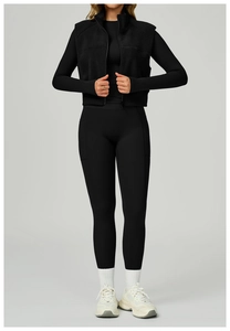 Détail du gilet de sport noir à col montant et legging taille haute avec poches latérales
