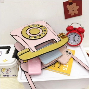 Pink retro telephone crossbody bag interior showing phone, power bank and wallet storage