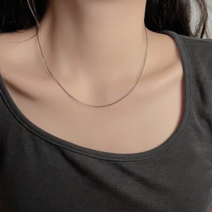 Minimalist silver stainless steel box chain necklace worn on model for casual look