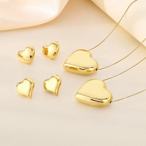 Détail de parure bijoux cœur 3D plaqué or 18 carats avec colliers et boucles sur soie