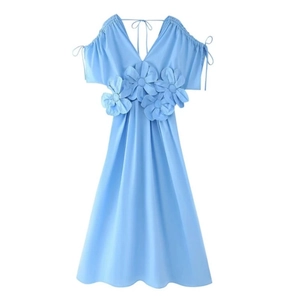 Detail of light blue V-neck dress featuring handmade 3D floral accents and tie shoulder straps