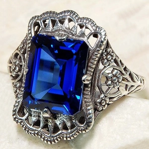 Bague vintage avec motif évidé et zircon bleu royal de taille émeraude sur marbre