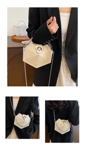Detail view of a beige hexagonal crossbody bag with embossed floral texture and chain