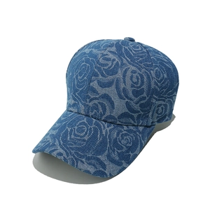 Blue denim baseball cap with rose floral print and curved brim from a 45-degree angle