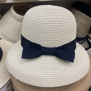 Detailed close-up of woven straw texture and elegant black ribbon bow on sun hat