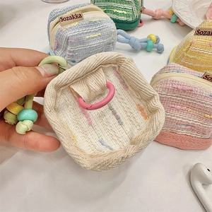 Macro shot of hand-woven fabric texture with pastel bead lanyard and secure zipper