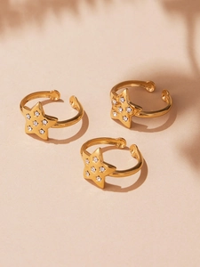 Detail shot of three gold adjustable star rings set with sparkling clear zircons