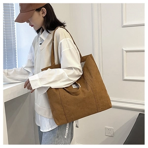 Nahaufnahme einer caramelbraunen Cord-Tasche mit weichem Stoff und kleinem Etikett