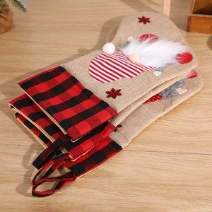 Linen Christmas stockings with gnome motif and red-black checkered cuffs on wood
