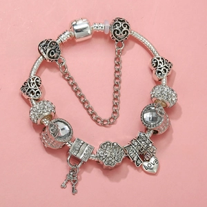 Close-up of silver-plated charm bracelet with heart, key, and Love lock pendants