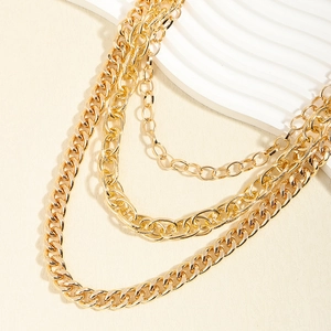 Detail of multi-layered gold metal chains showing varied textures and polished finish