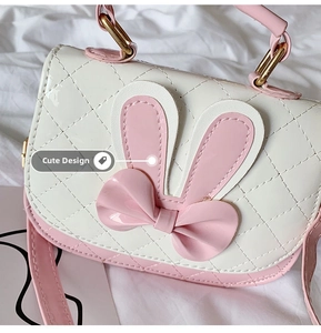 Detail of pink and white quilted girl handbag with bunny ears and 3D bow accent