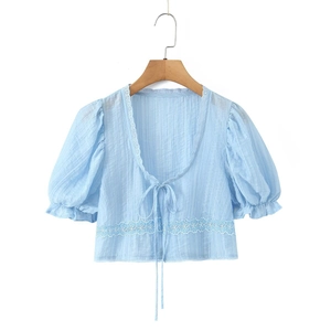 Top court bleu clair à manches bouffantes avec lacets et broderie blanche sur cintre