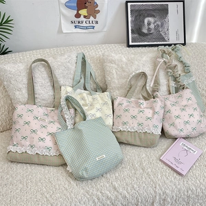 Close-up of pastoral canvas tote bag featuring lace trim and a delicate bow pattern print