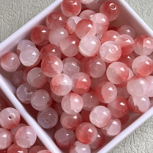 Macro shot of red and pink gradient ice-crack glass beads in a white square box