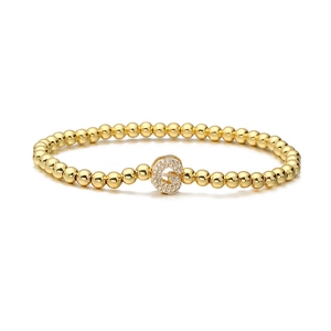 Detailed view of golden beaded bracelet featuring a shimmering zircon-inlaid letter G charm