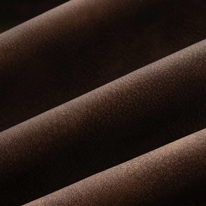 Detailed macro view of dark brown faux suede jacket fabric with frosted matte texture