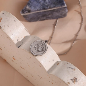 Détail d'un collier rond en acier inoxydable avec gravures d'empreintes de mains et de pieds