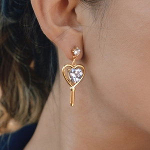 Orecchini a chiave a cuore in acciaio dorato con zircone scintillante indossati da modella