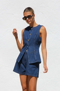 Détails d'un ensemble en denim bleu foncé avec un gilet sans manches et un short à boutons