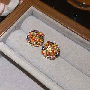 Detail shot of gold-plated rainbow zircon stud earrings in a luxury jewelry box