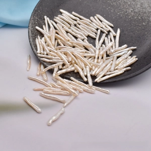 Close-up of natural baroque freshwater stick pearls in a grey ceramic dish