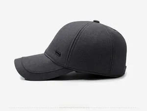 Detailed side view of dark grey winter baseball cap featuring a metal logo and fabric texture
