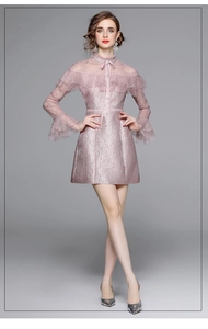 Détail d'une robe en tulle brodé rose avec poignet à volants et texture dentelle élégante