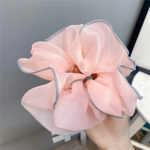 Macro detail of pink chiffon scrunchie featuring elegant grey contrast piped edges