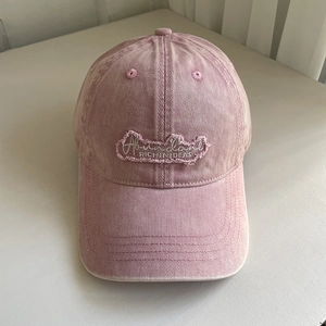 Close-up of vintage pink washed cotton baseball cap with white Abundant embroidery