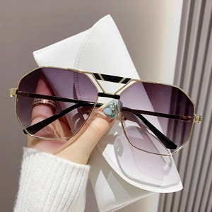 Klassische Polygon-Sonnenbrille mit lila Verlaufsgläsern und Metallrahmen in einem Etui