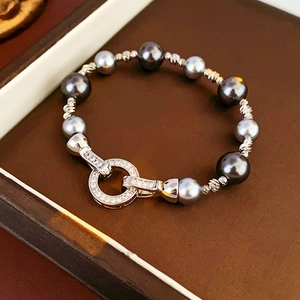 Detail of grey pearl bracelet with zircon clasp lying in a luxury jewelry box