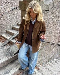 Outdoor street style outfit featuring a brown suede jacket and light blue wide-leg jeans
