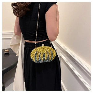 Detail of beaded leaf pattern handbag with gold chain strap on female model