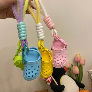 Detailed view of colorful mini clog shoe keychains with woven straps and metal hooks